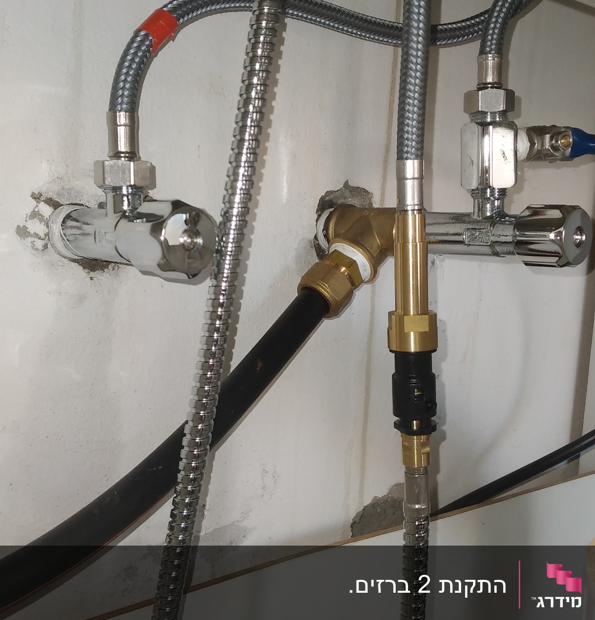 צינורות מתכת מחוברים לקיר עם ברזים ומחברים
